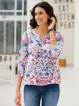 Woman wearing a long sleeve floral shirt.