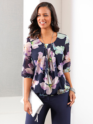 Woman wearing a pleated floral blouse.