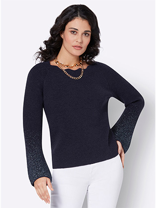 Woman wearing a metallic flare sleeve sweater.